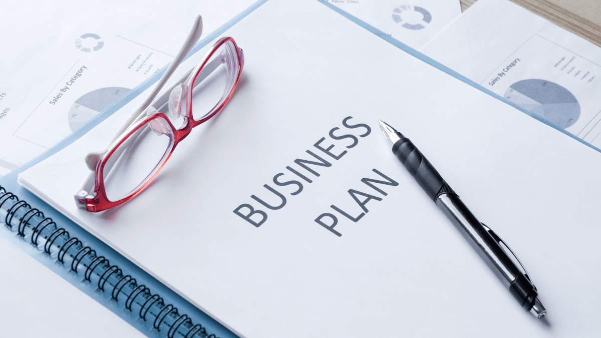 business plan with glasses and pen | creating a septic tank business plan | ServiceCore software for portable restroom & dumpster companies