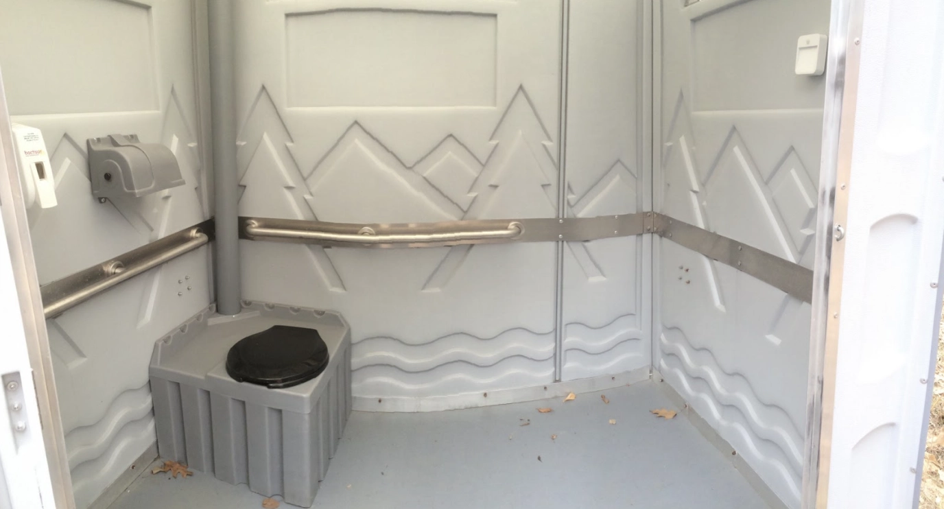 Inside of a luxury portable restroom with mountains on the wall panels - Why Your Porta Potty Rental Business Needs ADA-Approved Units - ServiceCore Blog