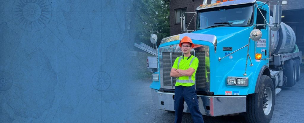 man with crossed arms standing in front of septic pump truck | Tips for Naming Your Septic Pumping Business | ServiceCore software for portable restroom & dumpster companies”