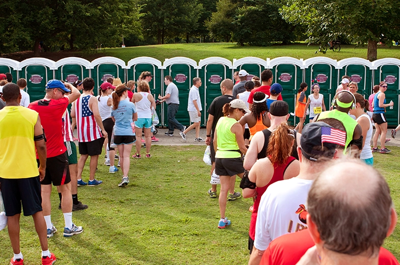 Crowd lined up waiting for porta potty - Types of Insurance Portable Restroom Operators Need - ServiceCore Blog