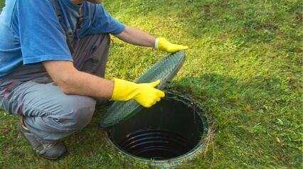 man taking off lid of septic tank | Where can i purchase a septic tank | ServiceCore software for portable restroom & dumpster companies”