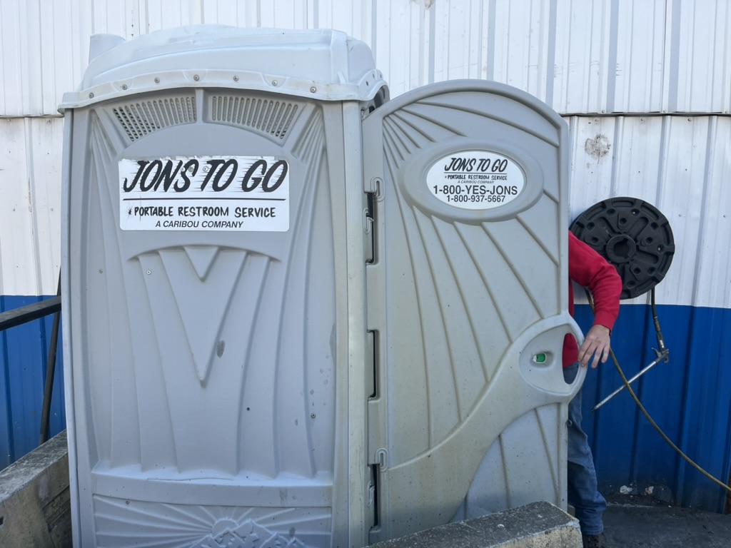 Jons to Go porta Potty being opened by a driver servicing the unit